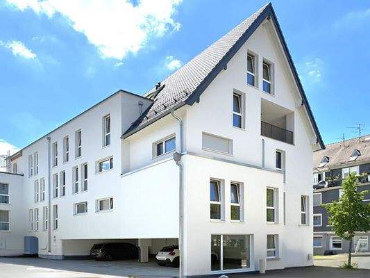 Hausansicht mit Parkplätzen