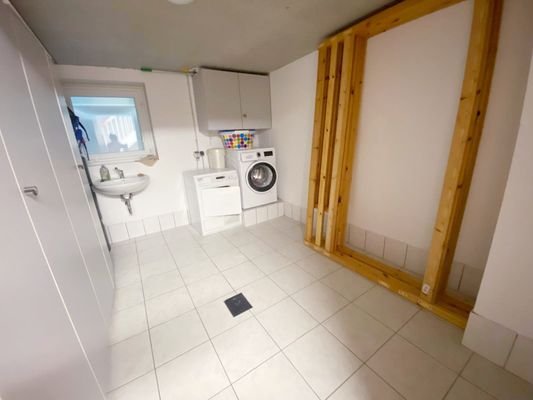 Waschbereich mit Waschmaschine im Keller