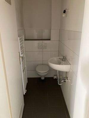 BEISPIELBILD: Gäste WC mit weiße Wandfliesen und grauen Bodenfliesen