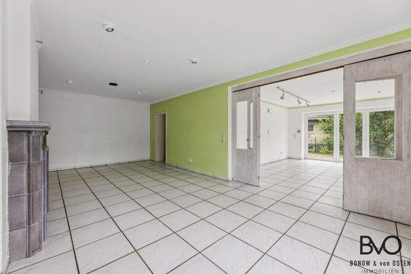 Gemütlicher Wohnraum mit Kamin und Blick ins Grüne