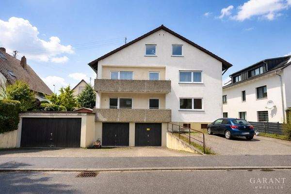 Helles Haus mit schwarzen Garagentoren