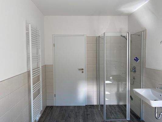 Bad mit zusätzlichem Handtuchheizkörper und Blick zur Dusche