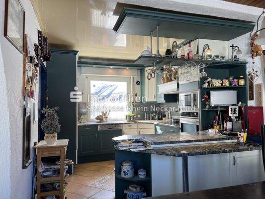 offene Küche mit Fliesenboden und heller Decke