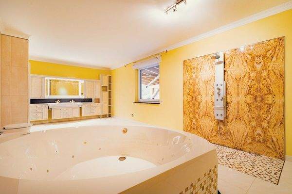 Wellnessbadezimmer mit Regenfalldusche und Whirlpoolbadewanne