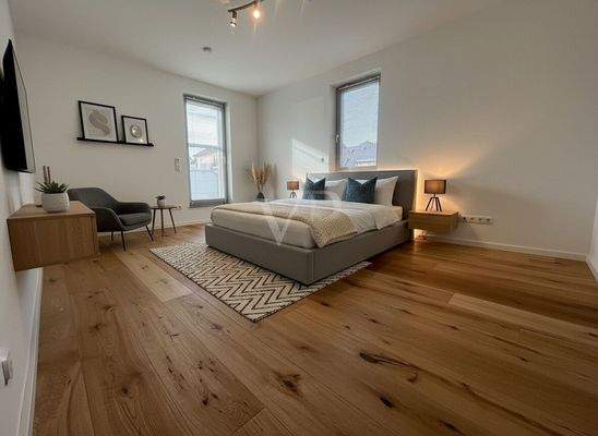 Schlafzimmer 1 mit Zugang zum Balkon und Beispielmöblierung