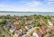 Haus mit Nachbarschaftsbebauung und dem See im Hintergrund
