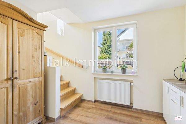 Gaderobenbereich mit Holztreppe ins Obergeschoss