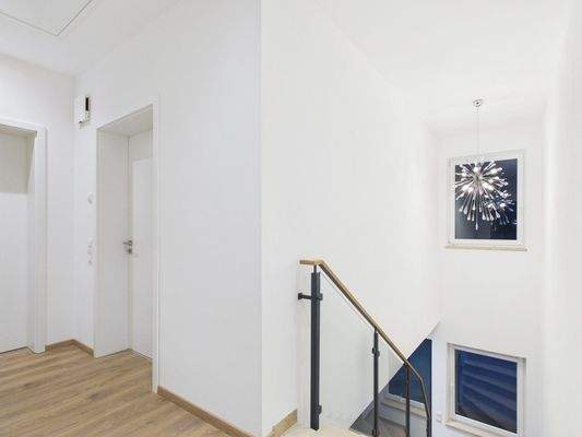 Treppenaufgang mit modernem Glas- und Metallgeländer