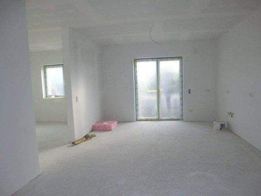 Küche mit Terrassenausgang, daneben Wohnzimmer 