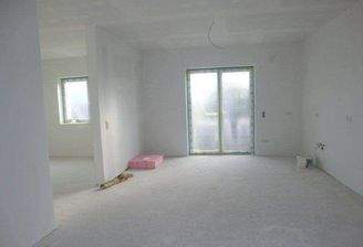 Küche mit Terrassenausgang, daneben Wohnzimmer 