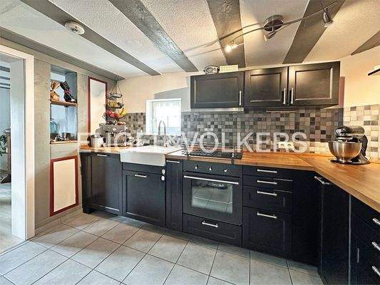 angrenzende Küche mit Einbauküche