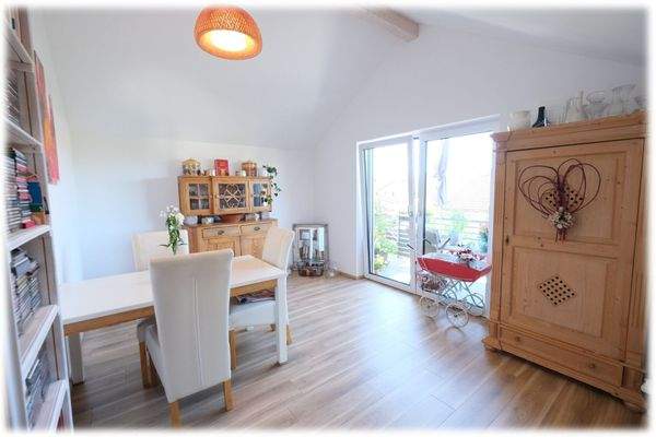 Der offene Wohn- und Essbereich mit offener Küche und angrenzendem Balkon