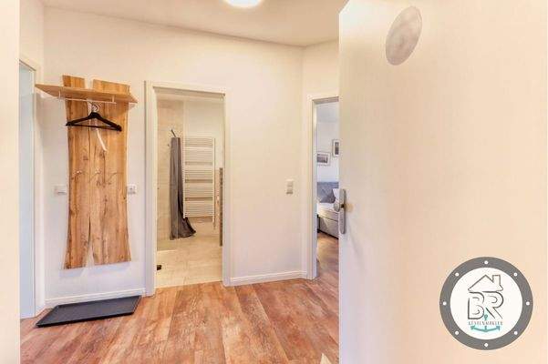 Einladender Eingangsbereich mit Garderobe und warmem Bodenbelag