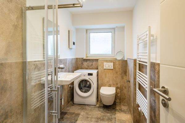 Modernes Tageslichtbad mit Waschmaschine