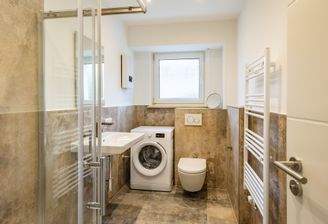 Modernes Tageslichtbad mit Waschmaschine