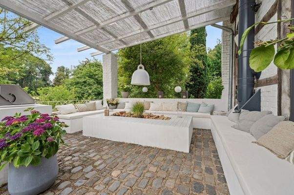 Überdachte Terrasse mit Lounge und Kamin