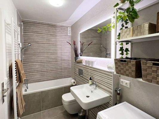 Badezimmer mit Duschwanne, Dusche sowie WC