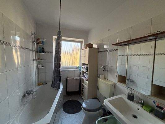 Badezimmer mit Badewanne, Fenster und Waschmaschin