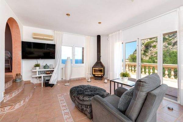 Helles Wohnzimmer mit Kamin und Zugang zur sonnigen Terrasse mit Weitblick