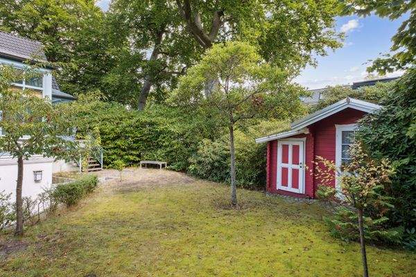 Südgarten mit Rasenfläche und überdachter Terrasse