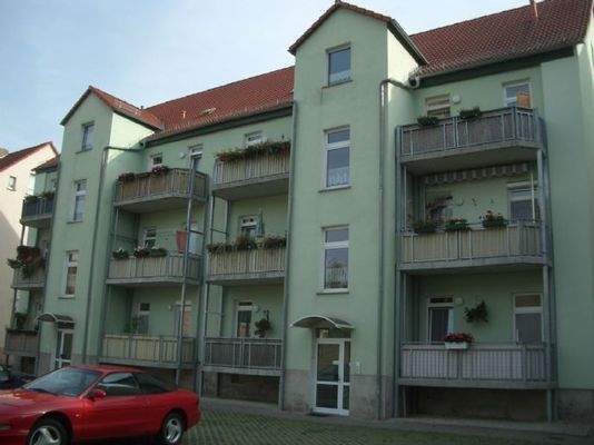 Rückansicht mit Balkon und Stellplätzen