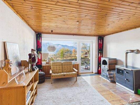 Wohnbereich mit Holzofen und Zugang Terrasse.
