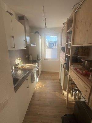 Einbauküche mit Zugang zur Loggia, helle Fronten, graue Rückwand 