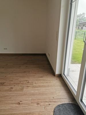 Wohnzimmer mit Terrassenzugang und offener Küche