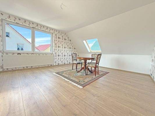 Geräumiges Wohnzimmer mit angrenzender Küche im Dachgeschoss