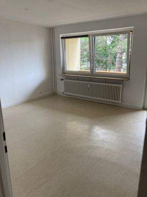 Wohnzimmer mit weißen Wänden und hellem Vinylboden