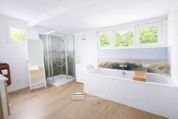 Tageslichtbad mit Wanne und Duschbereich