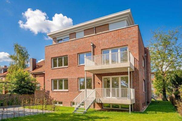 Hausansicht mit Blick vom Garten auf den Balkon und die Wohnung