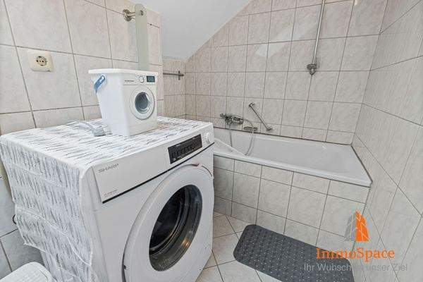 Duschbadewanne und Waschmaschine im Badezimmer