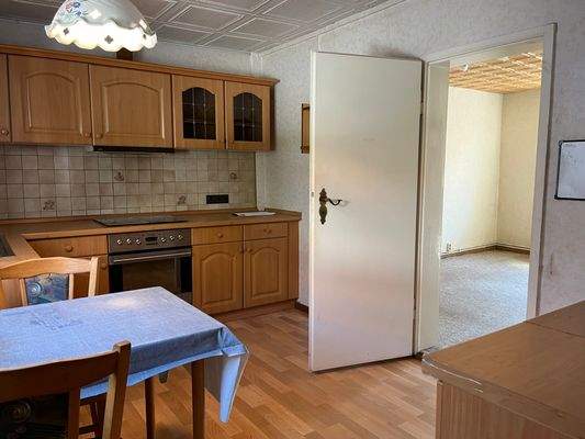 die Küche mit Zugang in ein weiteres Zimmer