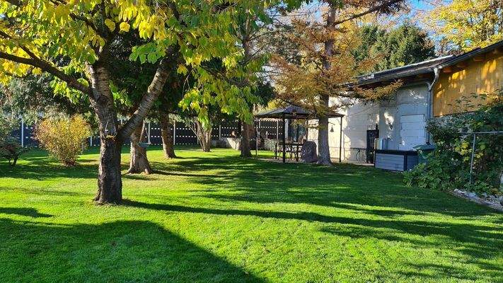 Garten mit Blick auf Sitzgruppe und Rohbau