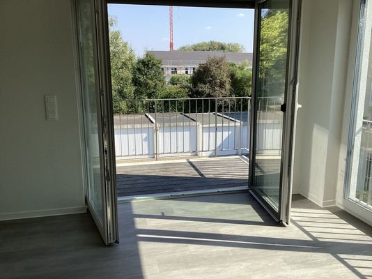 Wohnzimmer mit vollständig geöffneten Balkontüren