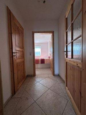 Schlafzimmer mit Vorflur und Zugang zum zugehörigen Badezimmer