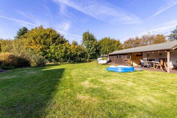 Blick in den Garten und auf das Gartenhaus mit überdachter Terasse