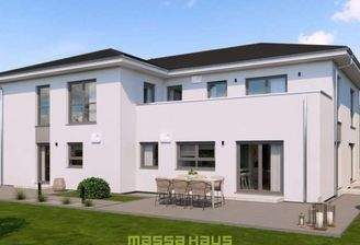 Rückansicht eines modernen massa haus Fertighauses mit Zeltdach, das als Mehrfamilienhaus konzipiert