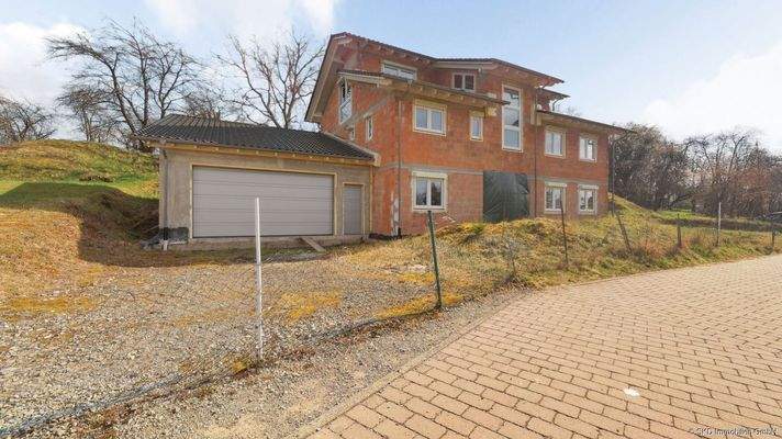 Straßenansicht mit Zufahrt zur Garage