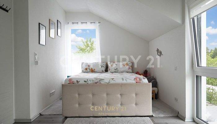 Helles Schlafzimmer unter dem Dach mit Blick ins Grüne