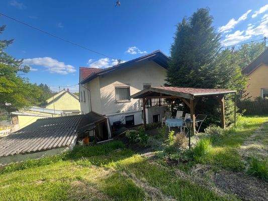 Überdachter Freisitz mit Rückansicht Haus