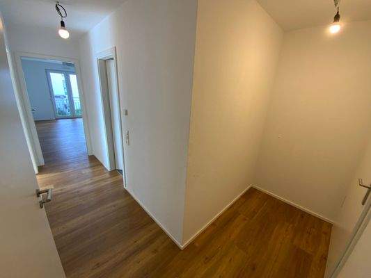 Flur im Eingangsbereich mit weißen Wänden und Vinylboden in Holzoptik