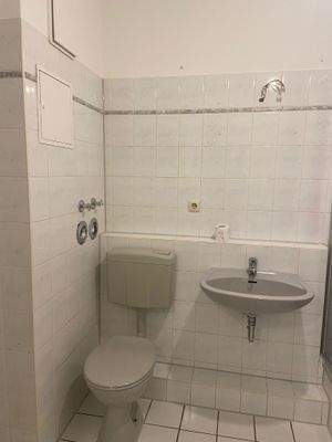 Badezimmer mit Toilette und Waschbecken.jpeg