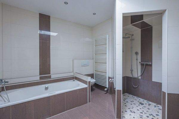 Das große Badezimmer mit Badewanne und Dusche