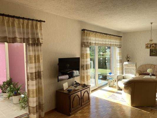 Wohnzimmer mit Zugang zum Wintergarten und zur Terrasse