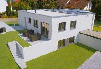 Modernes Haus mit Solarplatten und Terrasse