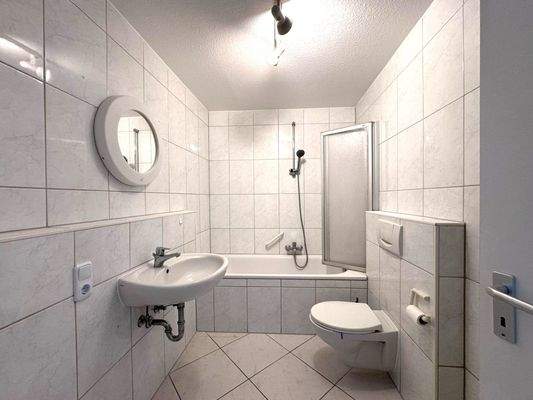 Badezimmer mit Badewanne und Waschmaschinenanschluss