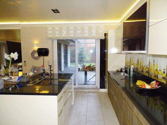 Links Kochinsel mit erweitertem Kochfeld und versenkbarer Tischhaube