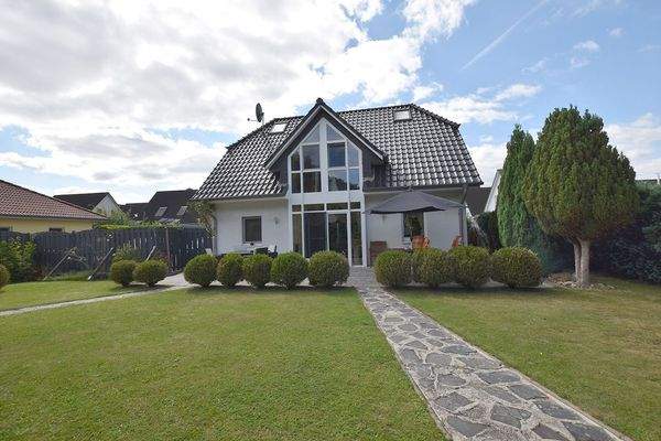 Zur Gartenseite dominiert der große, verglaste Erker die Architektur